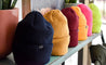 winter beanies lined up along shelf in assorted colours